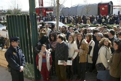 14 de marzo, elecciones generales, tres días después de los atentados. Hay largas colas de ciudadanos en los colegios electorales, como hacía tiempo que no se veían. En la imagen, decenas de personas esperan para poder votar en el colegio electoral Madrid Sur, justo en frente de la estación de El Pozo con uno de los trenes afectados por el atentado.