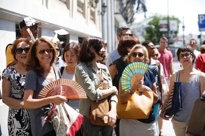 En la imagen, varias personas se abanican en la calle Alcalá, cerca de Sol, en Madrid.