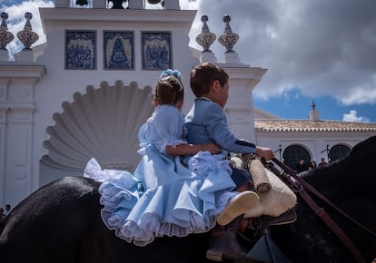 Dos pequeños romeros pasan montados a caballo ante el Santuario de la Virgen del Rocío, durante la presentación de las hermandades celebrada hoy en la aldea almonteña de El Rocío.

