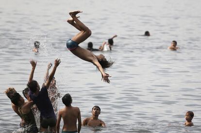 Jovens se divertem na baía de Manila apesar de estar proibido o banho nessas águas por estarem contaminadas. 20 de abril de 2014.