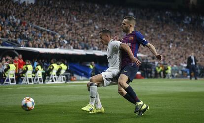 El jugador del Real Madrid, Lucas Vázquez, agunta el balón ante la presión del lateral del Barcelona, Jordi Alba.