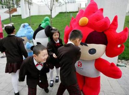 Niños chinos juegan con algunas de las mascotas diseñadas para la Olimpiada de Pekín en 2008.