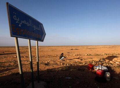 Un egipcio, que ha salido de Libia, espera a un taxi junto a todas sus pertenencias.