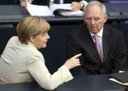 La canciller alemana, Angela Merkel (izq), charla con su ministro de Finanzas, Wolfgang Schäuble (der), el pasado jueves en una sesión del Bundestag (cámara baja) en Berlín, Alemania.