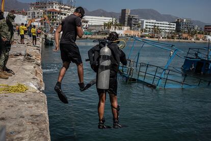 Buzos de la Marina se arrojan al mar durante las labores para sacar una embarcación en Acapulco.