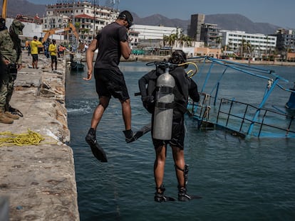 Buzos de la Marina se arrojan al mar durante las labores para sacar una embarcación en Acapulco.