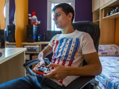 José Luis Flores plays on his PlayStation in his room.