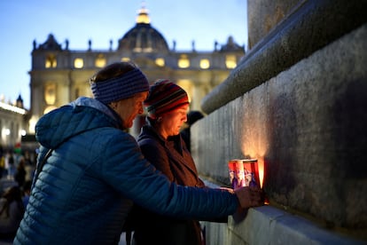 Varias personas colocan velas en el obelisco tras la muerte del Pontífice, en la plaza de San Pedro, en el Vaticano, el lunes.