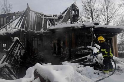 Un bombero del Distrito de Proteccin contra Incendios de Timberline roca agua en una casa cubierta de nieve que an arde por el incendio Marshall en el vecindario Rock Creek en Boulder, Colorado, el 1 de enero de 2022.