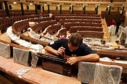 Un técnico trabaja en la instalación de monitores en los escaños del Congreso de los Diputados.