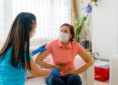 Una paciente con dolor abdominal que se somete a un examen médico con una sanitaria.