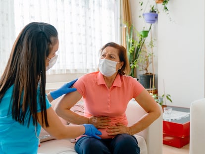 Una paciente con dolor abdominal que se somete a un examen médico con una sanitaria.