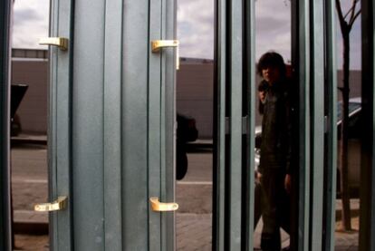 Una pareja pasa frente a una de las puertas de la calle de Mirasierra donde han robado uno de los tiradores.