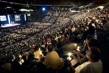 Los asistentes a la ceremonia inaugural de la conferencia celebrada en el Palau Sant Jordi encienden sus velas en memoria de las víctimas del sida.