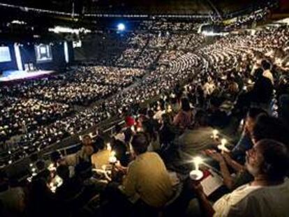 Los asistentes a la ceremonia inaugural de la conferencia celebrada en el Palau Sant Jordi encienden sus velas en memoria de las víctimas del sida.