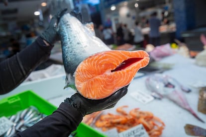 Un pescadero muestra un ejemplar de salmón en un establecimiento de de San Sebastián.