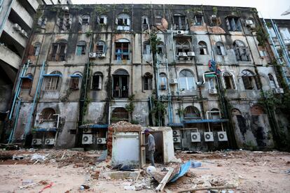 Un trabajador limpia después de derribar un edificio de la era colonial en el centro de Yangon (Myanmar).