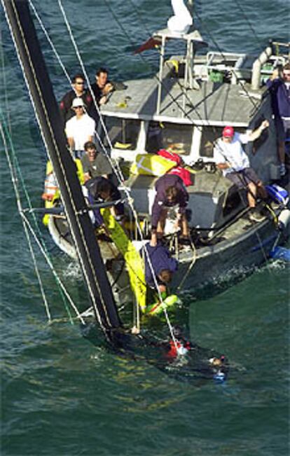 Colaboradores de Dennis Conner intentan sacar a flote el barco hundido.