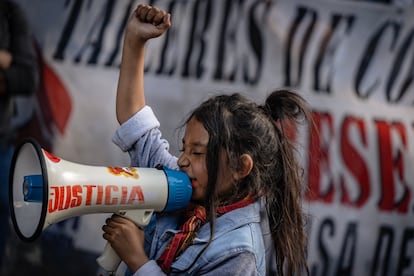 Una niña grita consignas a través de un megáfono.