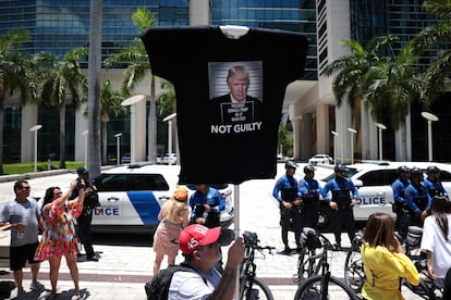 Un partidario de Donald Trump sujeta una camiseta con la efigie del expresidente sobre la que se lee "No culpable", en el exterior del juzgado de Miami donde comparece el exmandatario, este martes.