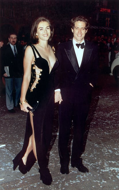 Liz Hurley y el vestido de imperdibles (1994). En 1994, Elizabeth Hurley asistió al estreno de ‘Cuatro bodas y un funeral’ junto a su entonces novio, Hugh Grant. Para la ocasión, Hurley eligió a última hora un despampanante vestido negro de Versace sostenido por grandes imperdibles dorados, diseñado por Gianni Versace. El diseño estaba a años luz de lo que solía verse en la alfombra roja por aquel entonces y lo atrevido del atuendo no solo catapultó a Hurley al estrellato internacional, sino que transformó la percepción de la moda y la celebridad en la alfombra roja. Al día siguiente, aquel vestido, que hoy cuenta con su propia página en Wikipedia, apareció en todos los periódicos e inauguró una nueva era en la industria de la moda.