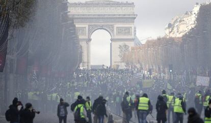 Uma nuvem de gás envolve os manifestantes, que levantaram barricadas na avenida Champs Élysées.