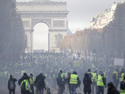 Uma nuvem de gás envolve os manifestantes, que levantaram barricadas na avenida Champs Élysées.