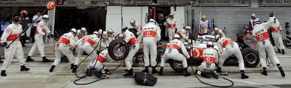 Los mecánicos de McLaren, durante un cambio de ruedas al coche de Lewis Hamilton.