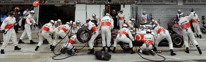Los mecánicos de McLaren, durante un cambio de ruedas al coche de Lewis Hamilton.