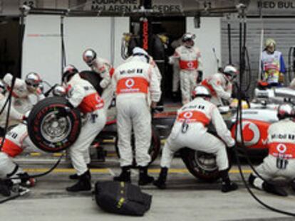 Los mecánicos de McLaren, durante un cambio de ruedas al coche de Lewis Hamilton.
