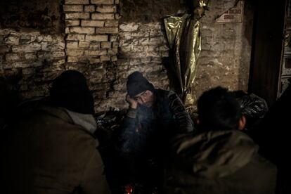 Un grupo de paquistaníes habla en el interior de la fábrica de ladrillos abandonada en Subótica que usan como refugio.