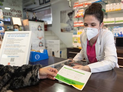 Una farmacéutica muestra un test de antígenos a una persona en la farmacia ‘Las Gemelas’, a 10 de enero de 2022, en Madrid.