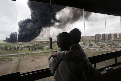 Un padre junto con su hijo ven el incendio desde su casa.