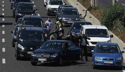 Un grup de taxistes discuteixen amb el conductor d'un vehicle amb llicència de transport de viatgers.