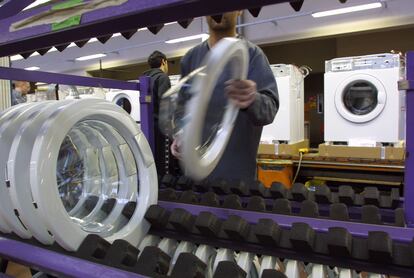 Un trabajador en una línea de montaje de lavadoras en la fábrica de AEG en Nuremberg, Alemania.