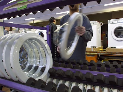 Un trabajador en una línea de montaje de lavadoras en la fábrica de AEG en Nuremberg, Alemania.