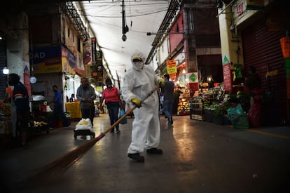 Un empleado protegido frente al coronavirus barre el suelo de la Central de Abastos (CEDA), el mercado mayorista de Ciudad de México. 