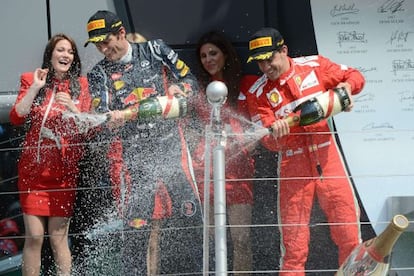 Red Bull&#039;s Mark Webber and Ferrari&#039;s Fernando Alonso spray champagne on the podium at the Silverstone circuit after the British Grand Prix.  