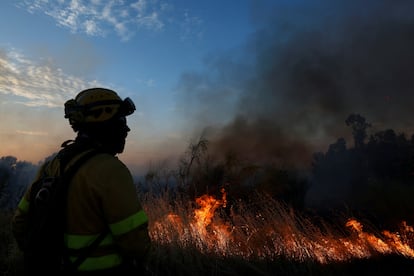 Personal de emergencias observa las llamas del incendio forestal en las afueras de Valmojado, este jueves.