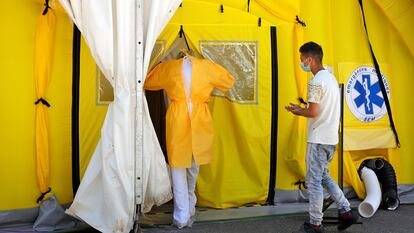 Un sanitario y un paciente entran en el hospital de campaña instalado ante el CUAP Prat de la Riba de Lleida, este jueves.