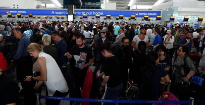 Viajeros de British Airways esperando en los mostradores del la Terminal 5 del aeropuerto londinense de Heathrow ayer domingo.