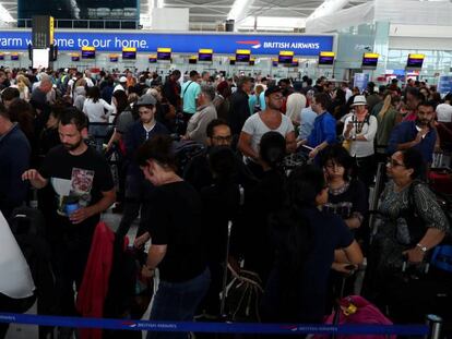 Viajeros de British Airways esperando en los mostradores del la Terminal 5 del aeropuerto londinense de Heathrow ayer domingo.