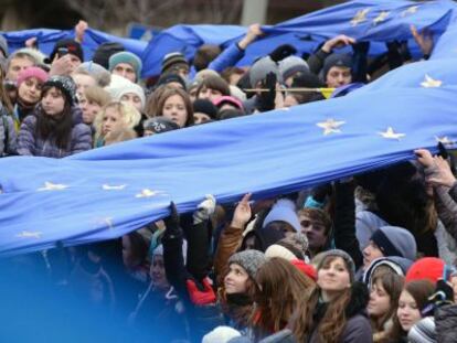 Decenas de estudiantes sostienen una enorme bandera de la UE.