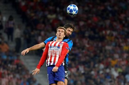El delantero del Atlético de Madrid, Antoine Griezmann trata de cabecear el balón ante el defensa del Brujas Benoit Poulain.