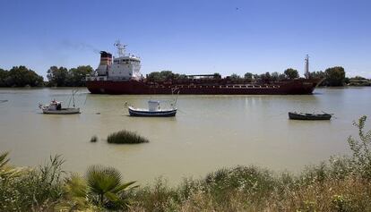Un barco navega por el río Guadalquivir, a la altura de Coria del Río.