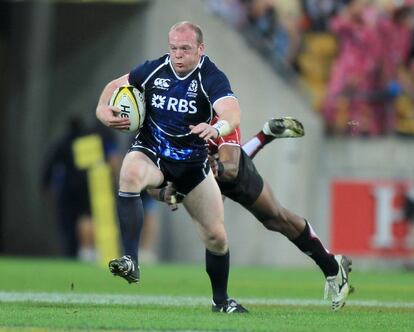 3/02/2002. Fraser Harkness de Escocia es placado por Osea Kolinisau de Japón, durante el Torneo de las Seis Naciones de rugby celebrado en Wellington.