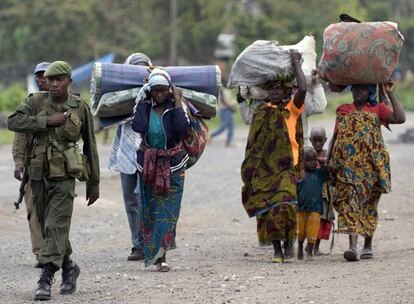 A pesar de la tregua, la población congoleña continúa su exilio hacia los campos de refugiados. En la imagen, un soldado camina junto a un grupo de mujeres en Goma, capital de la región de Kivu Norte. Los rebeldes se han acercado a esta ciudad estratégica en el este del país mientras que el ejército y los civiles emprenden la huida.