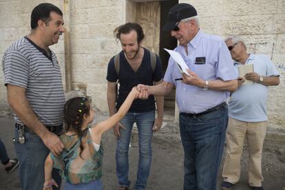 Vargas Llosa saluda a Darín una niña en el barrio palestino de Silwan.