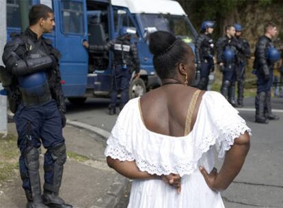 Los gendarmes franceses observan mientras el Colectivo Contra la Explotación (LKP) levanta una barricada el lunes en Guadalupe.