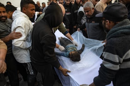 Varios hombres junto al cuerpo deun niño muerto en los ataques aéreos israelíes, en el hospital Al-Maadani de la ciudad de Gaza, este martes.